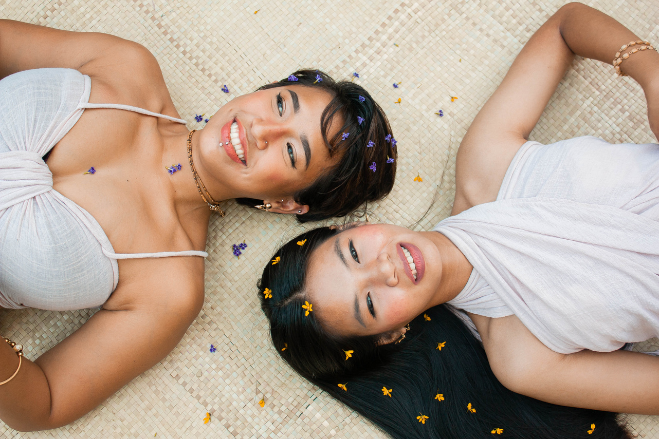Happy Women Lying on Banig Mat with Flowers